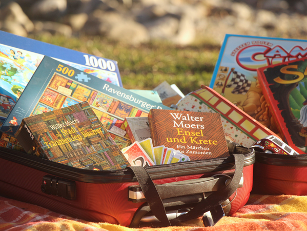 Symbolbild für Kofferflohmarkt: Ein Koffer, der mit Spielsachen, Kinderbücher und Puzzles gefüllt ist.