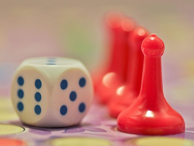 Bild mit einem Würfel und Spielfiguren